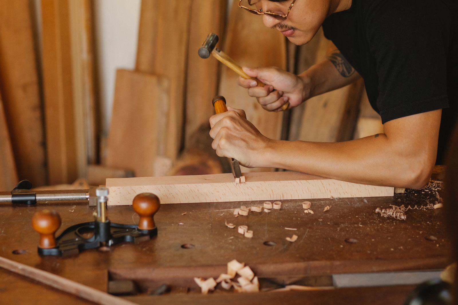 Artisan carving wood with traditional hand tools